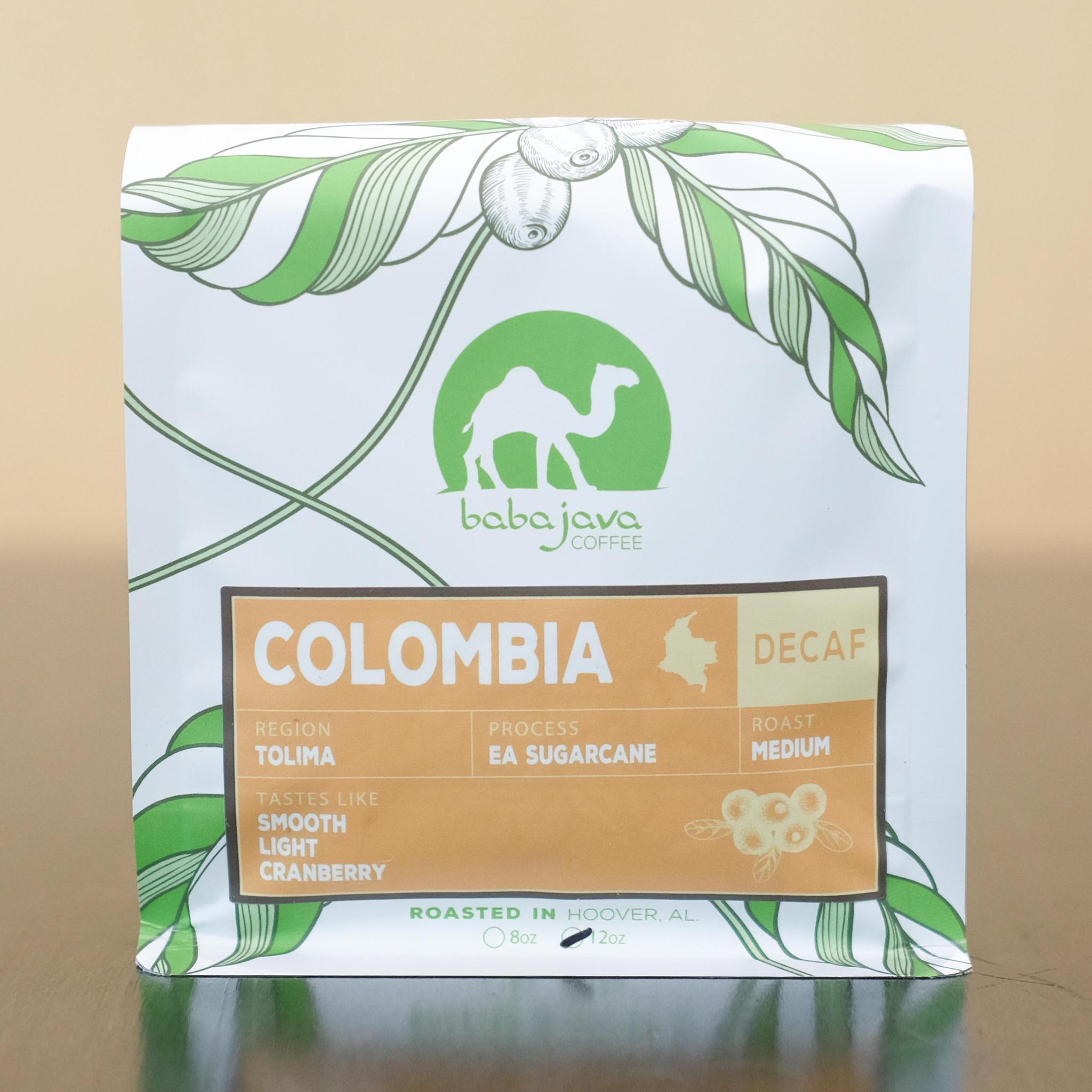 A bag of coffee with an orange label that reads Colombia. The bag has a drawing of a coffee plant and the Baba Java Coffee logo.