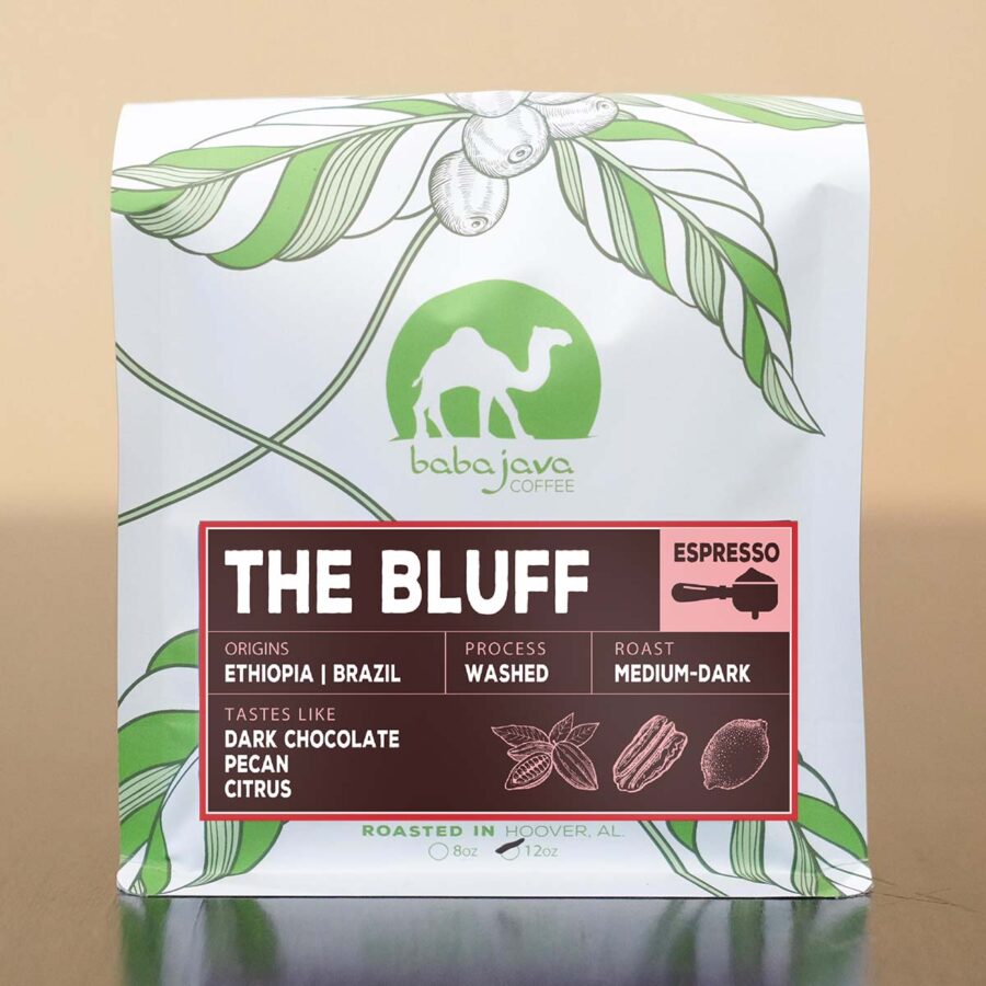 white bag with green coffee tree leaves and a marron label with pink trim and The Bluff written in white