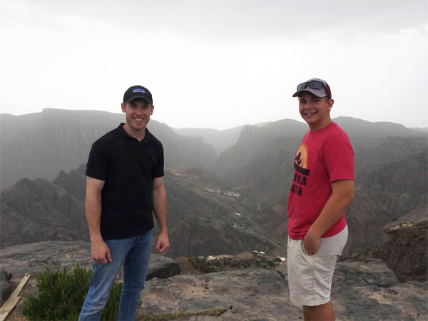 A young Joshua Parvin smiling with a friend while on a trip to the Oman desert.